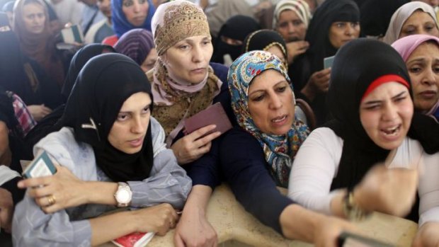 Suffocating closure: Palestinian women hoping to cross into Egypt present their passports at the Rafah border crossing in the southern Gaza Strip.