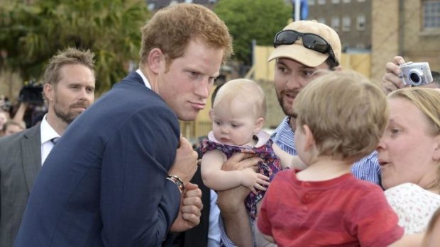 Prince Harry makes a funny face at a young child during his 2013 visit to Sydney.