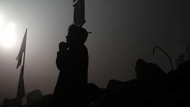 A relative of a trapped miner prays.