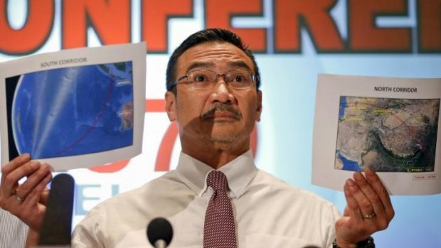 Malaysia's Acting Transport Minister Hishammuddin Hussein shows two maps with corridors of the last known possible location of the missing Malaysia Airlines MH370 plane as he addresses reporters at the Kuala Lumpur International Airport.