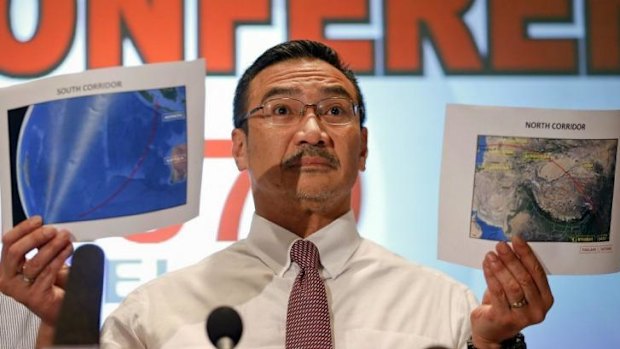 Malaysia's Acting Transport Minister Hishammuddin Hussein shows two maps with corridors of the last known possible location of the missing Malaysia Airlines MH370 plane as he addresses reporters at the Kuala Lumpur International Airport.