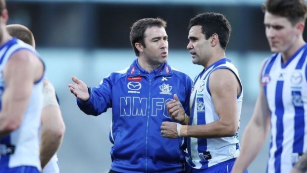 North Melbourne coach Brad Scott has a word with Lindsay Thomas at half-time.