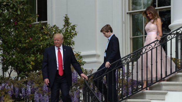 President Donald Trump, followed by his son Barron and first lady Melania Trump.