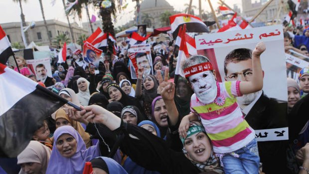 Supporters of Egypt's ousted president Mohammed Morsi during a protest in Nahda Square on Tuesday, where protesters are camping. The posters reads: "Yes for legitimacy, no for coup."
