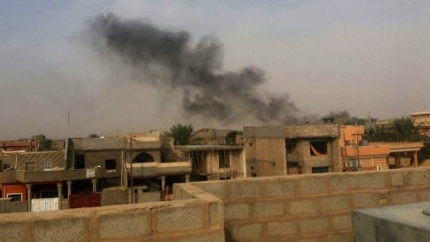 Under pressure: Smoke plumes  over buildings in the Iraqi town of Hit, in western Anbar province.