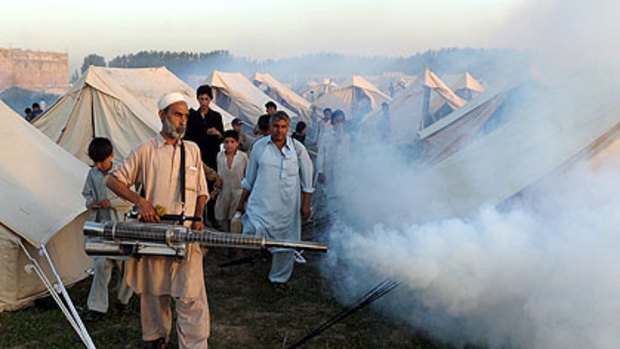 A makeshift refugee camp near the town of Mardan, in Pakistan's North-West Frontier Province, is sprayed as a precaution against disease.