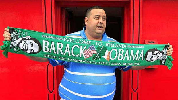 A man holds an Obama souvenir scarf outside a pub in Moneygall.