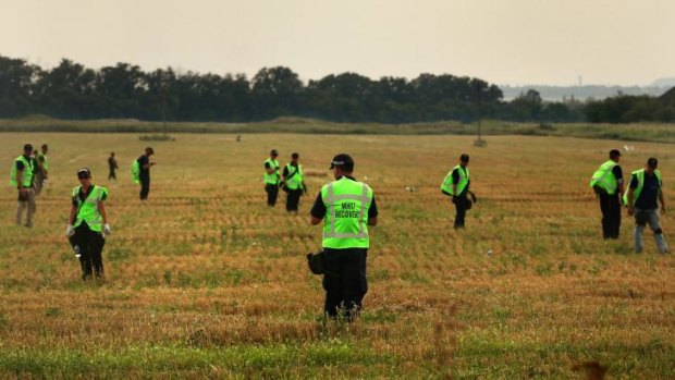 Australian police search the fields for human remains with their Malaysian and Dutch counterparts.