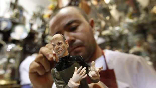 A popular figure: Artist Gennaro di Virgilio paints a figurine of Apple founder Steve Jobs in his Naples shop.