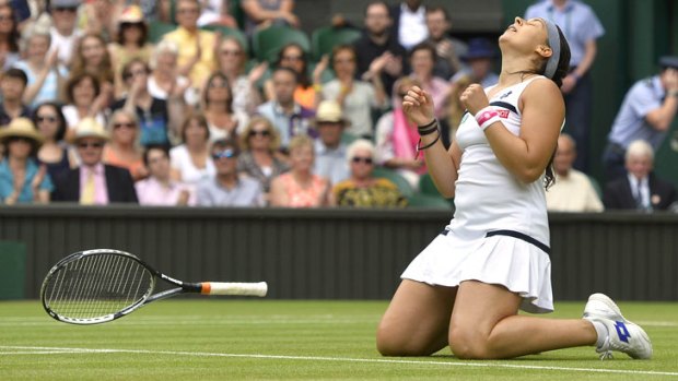 Marion Bartoli of France reacts as she defeats Kirsten Flipkens of Belgium in their women's semi-final tennis match at the Wimbledon Tennis Championships in London.