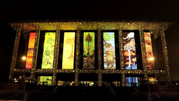 The National Library of Australia is illuminated for the Enlighten Festival. by a  giant light projection. A small number of people braved torrential rain for a glimpse. The artist who created the projection was Paul Summerfield.