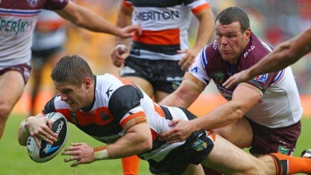 Wests Tigers centre Chris Lawrence evades Manly prop Jason King to score.