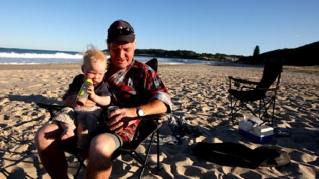 Splendid isolation... Reggie Weimer with his son Joe, 17 months, soaks up the peace of Catherine Hill Bay, which yesterday escaped a 600-home development.