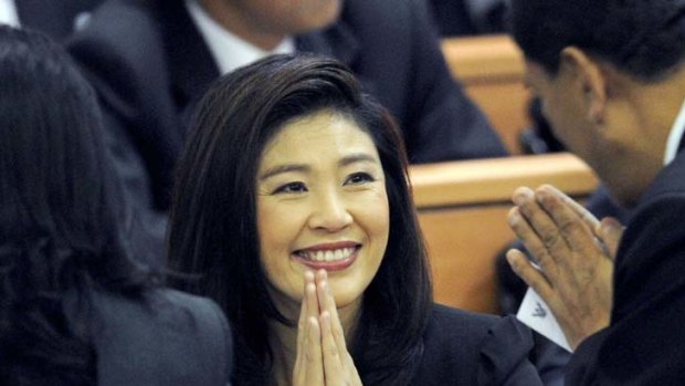 Yingluck Shinawatra greets fellow MPs as the Thai Parliament convenes.