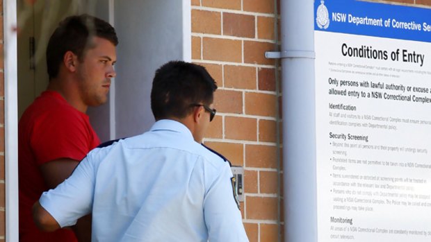 Long arm of the law ... Danny Wicks is led from Belmont police station to face court yesterday.