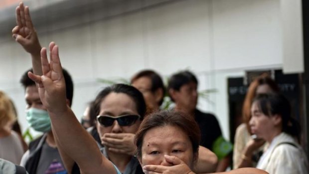 Anti-coup protesters flashing the three-finger salute during a gathering in Bangkok.
