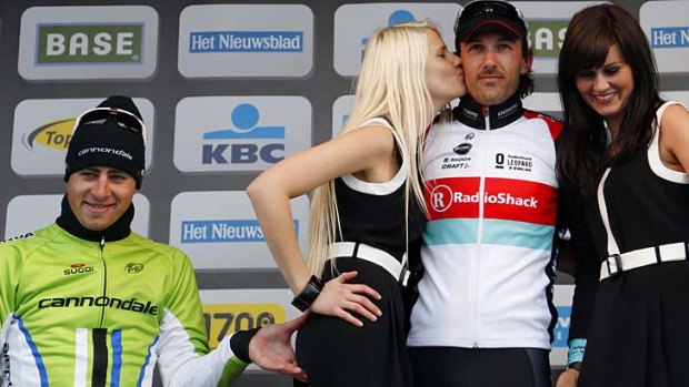 Cannondale team rider Peter Sagan is caught pinching the bottom of a podium girl as she kisses RadioShack team rider Fabian Cancellara of Switzerland.