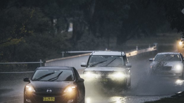 A car passes through water on Parkes Way. 