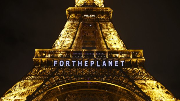 Slogans were projected on the Eiffel Tower as the climate conference in Paris pushed into overtime.