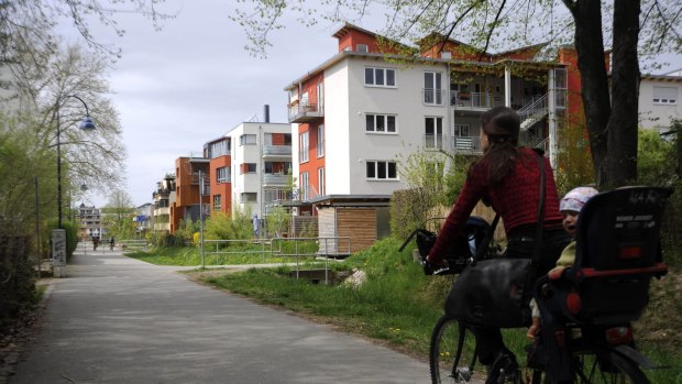 A woman cycles down a street in the suburb of Vauban, on the outskirts of Freiburg. Residents of this experimental new district are suburban pioneers, they have given up their cars. 