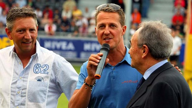 Michael Schumacher (centre) speaks during a charity soccer match between a team of Formula 1 drivers and a team of Belgian VIPs, at the AS Eupen football field in Eupen on August 24.