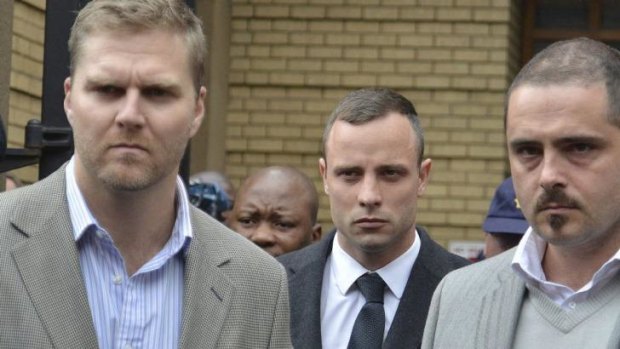 'I did not fire at Reeva!' ... South African Paralympic star Oscar Pistorius (centre) leaves the North Gauteng High Court in Pretoria.