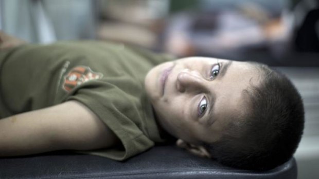 A boy wounded in an Israeli strike on a compound housing a UN school in Jabalia waits for treatment.