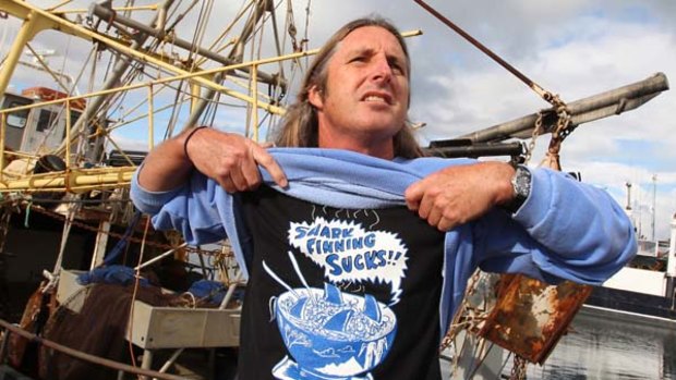 Tim Winton makes a stand in front of a gill-fishing boat at Fremantle's Fishing Boat Harbour. Winton is advocating that Australians be more selective on eating endangered shark species,.
