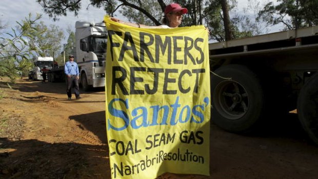 NSW farmers Ted and Julia Borowski (holding banner) protest against Santos' coal seam gas project near the Pilliga State Forest.