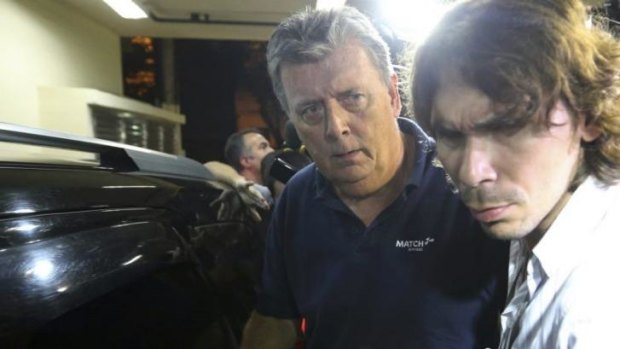 Ray Whelan, left, arrives at a police station in Rio de Janeiro on Monday.