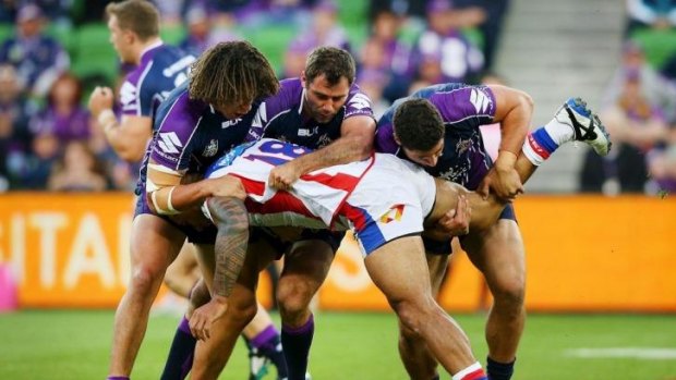 Three men in: David Fa'alogo is tackled by Kevin Proctor, Cameron Smith and Kenny Bromwich during the same match in which Knights teammate Alex McKinnon's career was ended.
