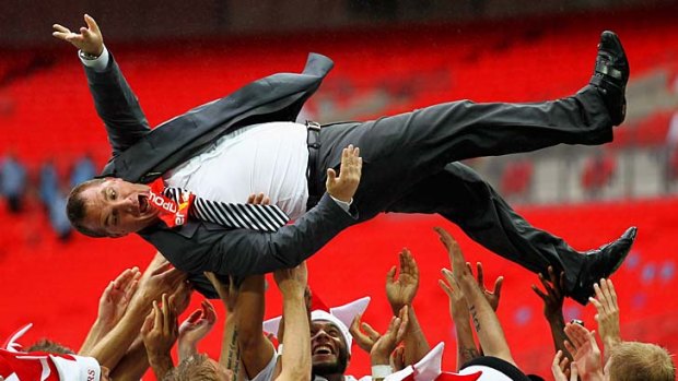 Swansea manager Brendan Rodgers is thrown up in the air by his players after they won the npower Championship playoff final against Reading on May 30 last year.