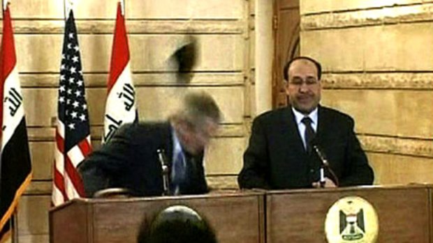 George Bush ducks a shoe thrown by an Iraqi journalist.