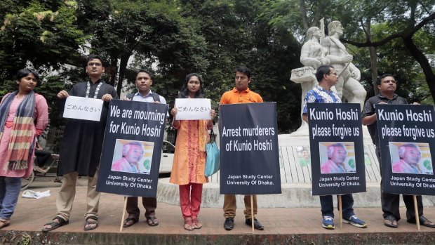 Bangladeshis stand with placards that read "I am sorry" during a human chain demanding the arrest  of murderers of Japanese citizen Kunio Hoshi in Dhaka last Saturday. 