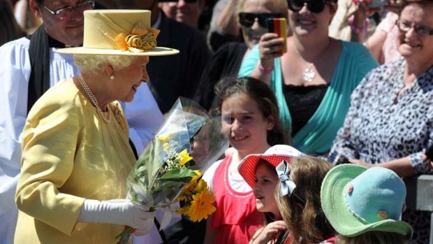 Floral reception ... the Queen receives flowers from schoolchildren during her visit to South Bank in Brisbane yesterday.