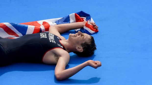 Gold ... Alistair Brownlee lays exhausted after crossing the finishing line.