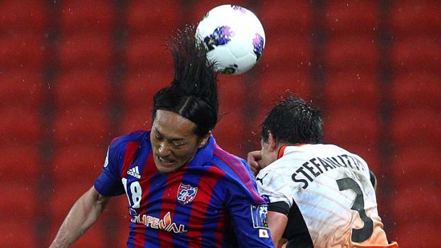 Ishikawa Naohiro of FC Tokyo and Shane Stefanutto of the Roar compete for the ball during the AFC Asian Champions League match.