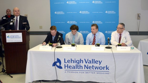 John Fletcher, left, president of the Lehigh Valley Hospital-Hazleton talks about treatment of Justin Smith, seated third from right, with Gerald Coleman, his father Don Smith, and Dr James Wu, right. 