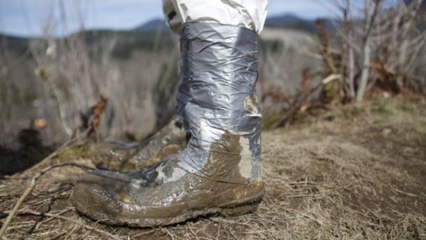 An emergency worker's boot is fastened with duct tape to avoid contamination after the Washington state mudslide.