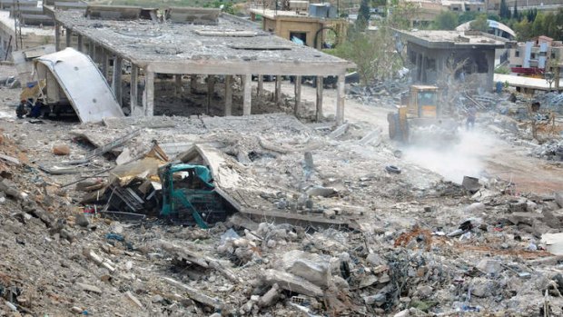 ''An act of war'': Bulldozers work to clear the wreckage after the air strikes flattened buildings in Damascus.