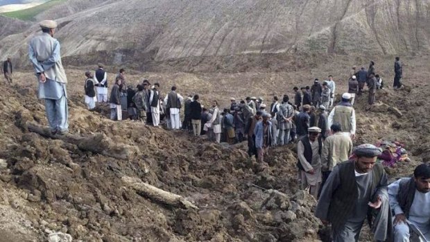 Afghan villagers gather at the site of a landslide through to have trapped 2000. 