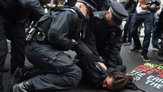 A protester is detained on Oxford Street in London as part of a protest ahead of next week's G8 summit in Northern Ireland. Next week will see Enniskillen in Northern Ireland host the two day G8 summit where international leaders including Britain's Prime Minister David Cameron and US President Barack Obama take part in the two day event.