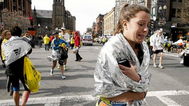 An unidentified Boston Marathon runner leaves the course crying near Copley Square following two bomb blasts.