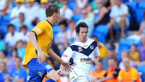 Not so close: Victory's Robbie Kruse, right, looks to bring the ball under control at Gold Coast's Skilled Park last night.