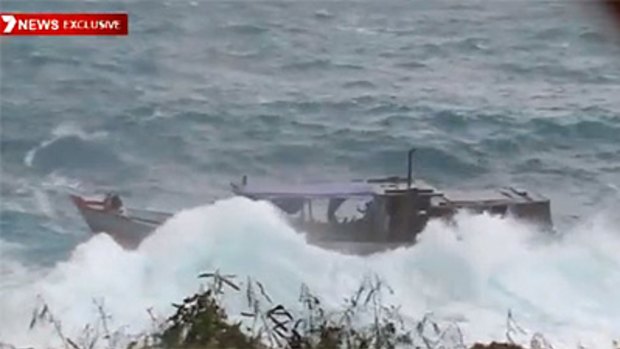 The stricken asylum boat in heavy swells off Christmas Island after smashing into the rocks.