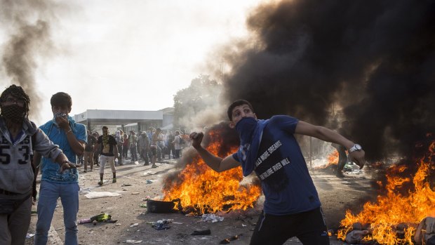 Horgos, Serbia. A protesting refugee throws projectiles at Hungarian police at the Horgos border crossing in Serbia. 