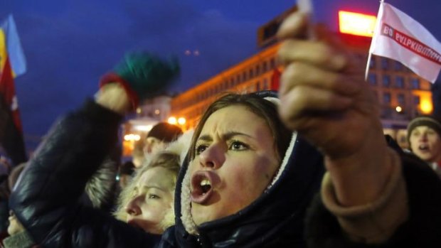 Protesters shout and wave flags during a rally at the central Independence Square in Kiev, Ukraine. 