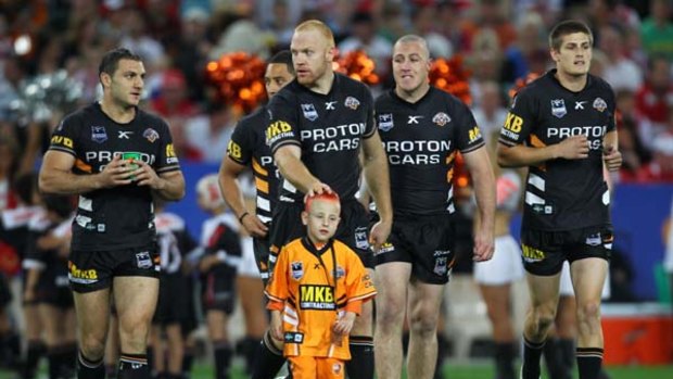 Greatest fan . . . The Wests Tigers run out at ANZ Stadium on Saturday night with five-year-old Lleyton Giles, who has a terminal liver disease.