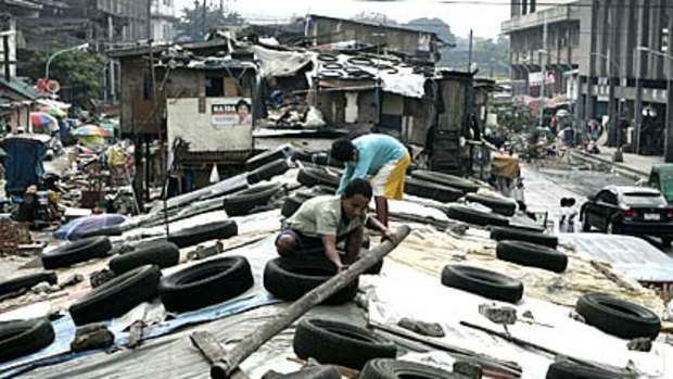 Residents put old tires and wooden sticks on their rooftops in preparations for strong winds brought by Typhoon Mirinae.