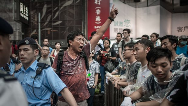 An anti-protester (left) shouts at pro-democracy demonstrators in an occupied area of Hong Kong.